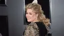 Penyanyi Kelly Clarkson membawa mawar putih ketika menghadiri karpet merah Grammy Awards 2018 di New York, Minggu (28/1). Bunga ini menjadi lambang dukungan melawan kesetaraan gender dan pelecehan seksual di industri musik. (Evan Agostini/Invision/AP)