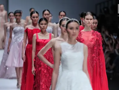Sejumlah model berjalan diatas catwalk membawakan rancangan desainer Cherryn Lim di Jakarta Fashion Week 2018 di Senayan City, Jakarta, Kamis (26/10). Cherryn Lim mempersembahkan 25 koleksi gaun malam dan 5 gaun pengantin. (Liputan6.com/Faizal Fanani)