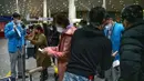 Pekerja membantu pelancong mengisi status kesehatan elektronik COVID-19 mereka di area kedatangan internasional di Bandara Internasional Beijing, China (9/1/2023). Pelancong internasional pertama tiba di China tanpa karantina wajib yang telah diberlakukan pada awal penerbangan. Pandemi tiga tahun lalu setelah pembatasan dicabut mulai hari Minggu. (AP/Mark Schiefelbein)