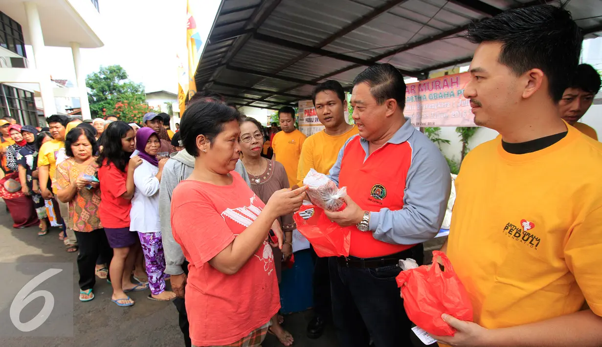 Irjen Pol (Purn) Mudji Waluyo memberikan paket sembako murah kepada warga dalam rangka  kegiatan Pasar Murah Artha Graha Peduli bekerjasama dengan Induk Koperasi Kepolisian (INKOPPOL) di kawasan Pegangsaan, Jakarta, Rabu (29/6).(Liputan6.com/Angga Yuniar)