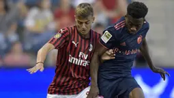 Penyerang AC Milan, Daniel Maldini menggiring bola dari kawalan pemain Bayern Munchen, Kingsley Coman selama pertandingan International Champions Cup 2019 di Kansas City, Amerika Serikat (24/7/2019). AC Milan kalah tipis 1-0 atas Munchen berkat gol Leon Goretzka. (AFP Photo/Tim Vizer)