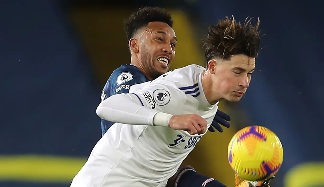 Striker Arsenal, Pierre Emerick Aubameyang (kiri) berebut bola dengan bek Leeds United, Robin Koch, dalam laga lanjutan Liga Inggris pekan ke-9 di Elland Road Stadium, Leeds, Minggu (22/11/2020). Arsenal bermain imbang 0-0 dengan Leeds United (AFP/Molly Darlington/Pool)