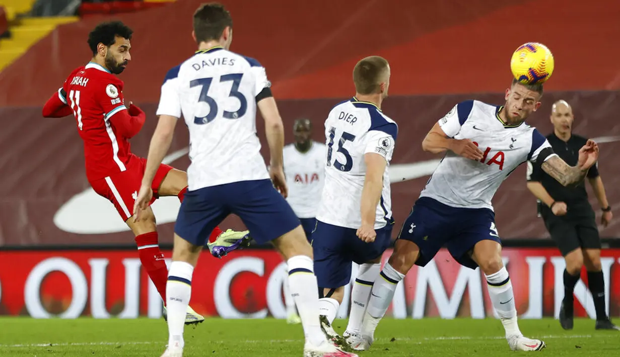 Pemain Liverpool Mohamed Salah (kiri) mencetak gol ke gawang Tottenham Hotspur pada pertandingan Liga Inggris di Anfield, Liverpool, Inggris, Rabu (16/12/2020). Liverpool mengudeta Tottenham dari puncak klasemen usai menang 2-1. (Clive Brunskill/ Pool via AP)