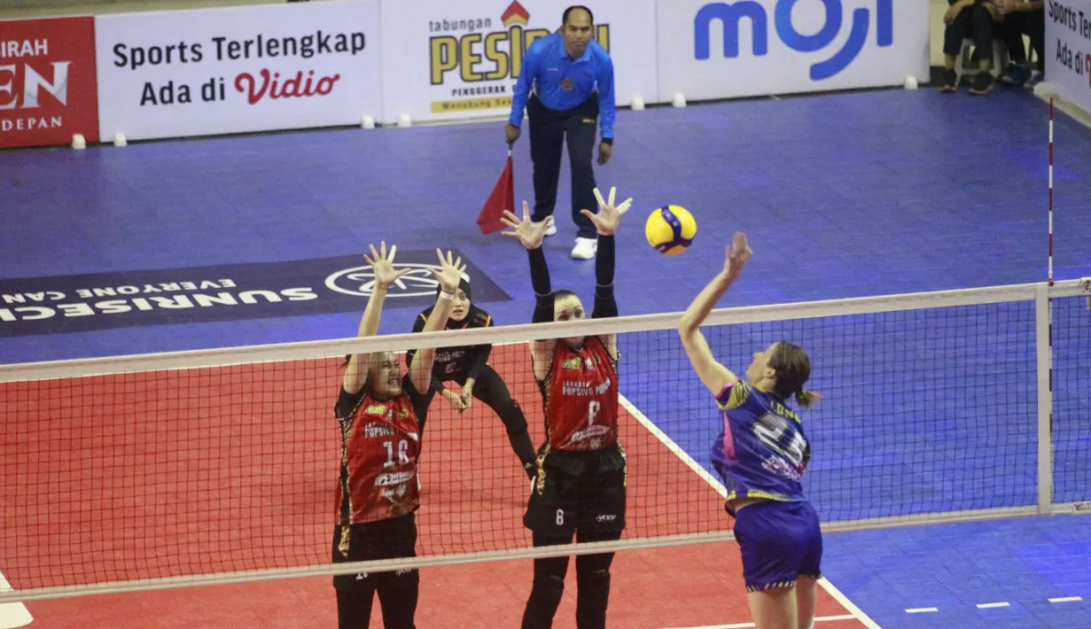 Pemain Jakarta Livin' Mandiri, Karsta Lowe (kanan) melepaskan spike yang berusaha diblok dua pemain Jakarta Popsivo Polwan, Irina Voronkova (tengah) dan Hanifa Nahda Aisa pada laga seri ketiga putaran pertama PLN Mobile Proliga 2024 di GOR PSCC, Palembang, Sumatera Selatan, Sabtu (11/5/2024). Jakarta Popsivo Polwan menang 3-0 (25-19, 25-21, 25-21). (Dok. PBVSI)