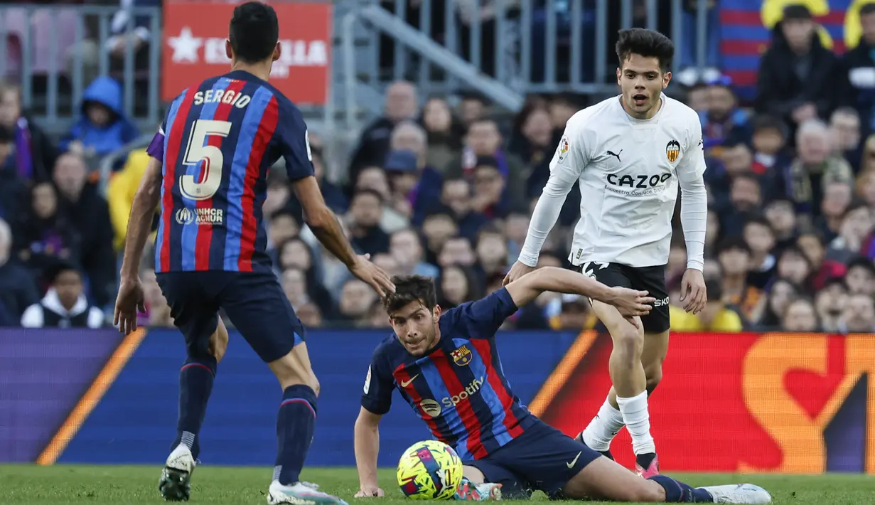 Bek Barcelona, Sergi Roberto (tengah)  mengontrol bola saat bertanding melawan Valencia selama pertandingan lanjutan La Liga Spanyol di stadion Camp Nou, Spanyol, Minggu (5/3/2023). Berkat kemenangan ini, Barcelona kini mengumpulkan 62 poin di puncak klasemen Liga Spanyol. (AP Photo/Joan Monfort)