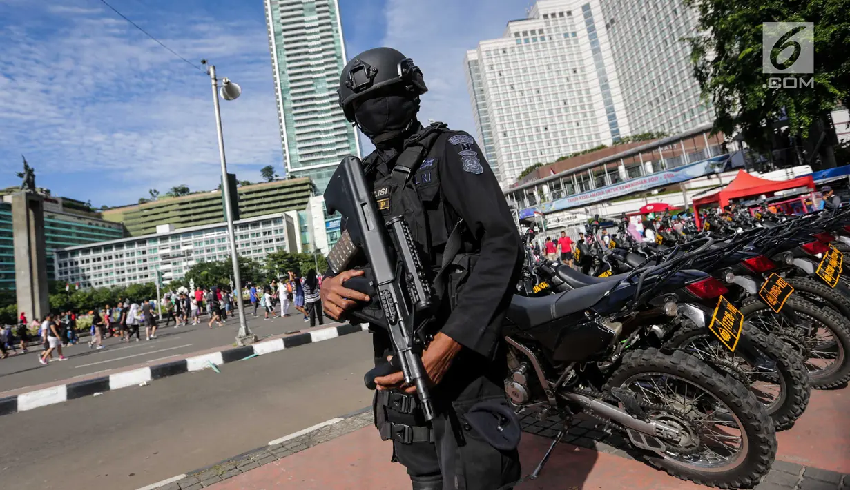 Pasukan Brimob bersenjata lengkap melakukan pengamanan saat Car Free Day di kawasan Bunderan HI, Jakarta, Minggu (24/12). Pengamanan tersebut merupakan salah satu rangkaian operasi Lilin 2017. (Liputan6.com/Faizal Fanani)