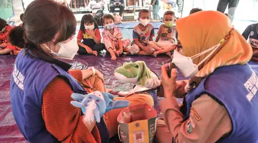 Petugas dari Dinas Sosial DKI Jakarta mengisahkan dongeng dengan boneka saat program trauma healing kepada anak-anak korban kebakaran yang mengungsi di SDN 09 Kebon Kosong, Kemayoran, Jakarta, Selasa (31/8/2021). (merdeka.com/Iqbal S. Nugroho)