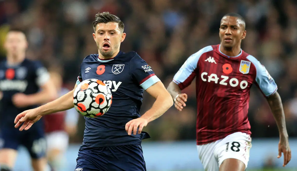 Bek Aston Villa, Ashley Young (kanan) bersaing dengan bek West Ham United, Aaron Cresswell pada pekan sepuluh Liga Inggris di Villa Park, Minggu (31/10/2021). West Ham United mengandaskan tuan rumah Aston Villa dengan skor 4-1. (Lindsey Parnaby / AFP)