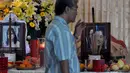 Seorang kerabat melintas di depan dua foto jenazah korban pesawat AirAsia QZ8501 yang disemayamkan di rumah duka Adi Jasa, Surabaya, Minggu (4/1/2015). (Liputan6.com/Johan Tallo)