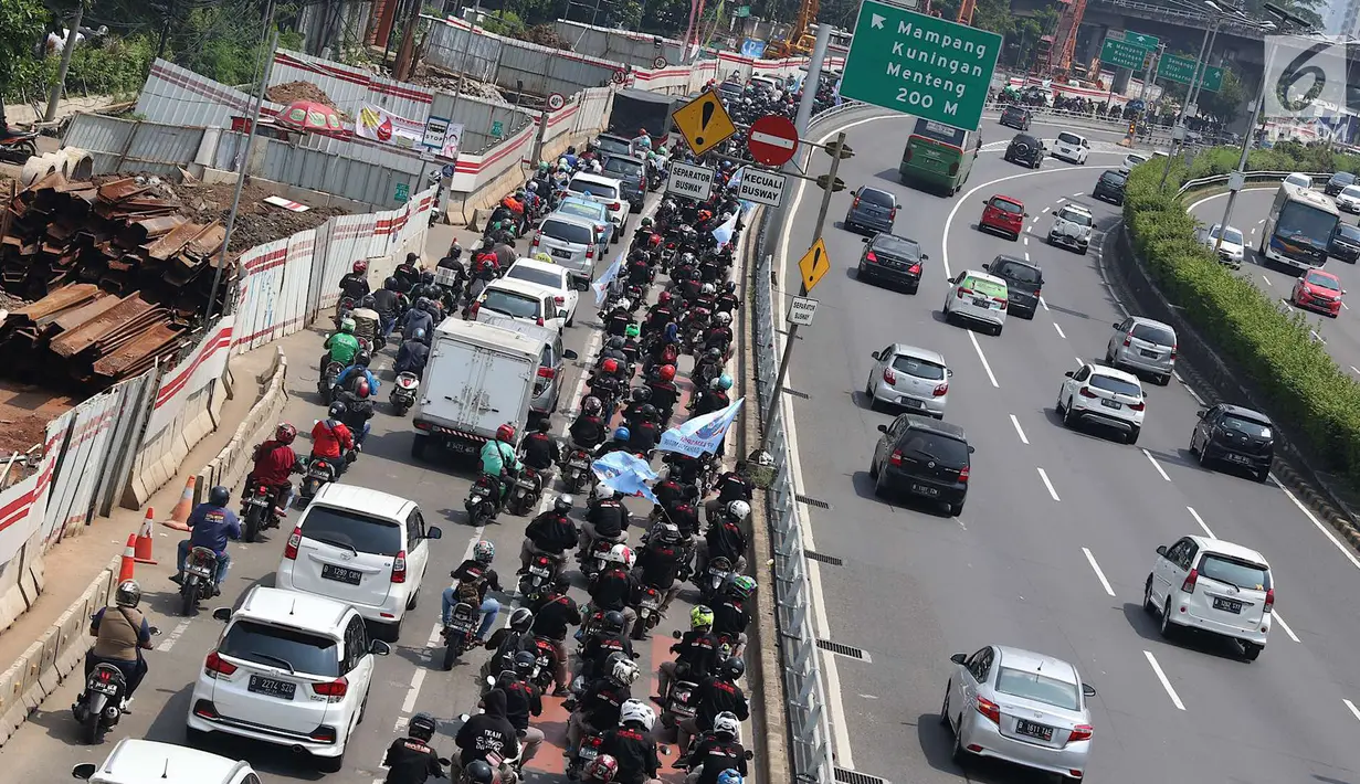 Konvoi buruh menggunakan sepeda motor melintas di Jalan Gatot Soebroto, Jakarta, Selasa (1/5). Ribuan buruh dari berbagai elemen memperingati perayaan Hari Buruh untuk menyampaikan aspirasi di sejumlah titik di Ibukota. (Liputan6.com/Immanuel Antonius)