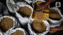 Pekerja memilah kedelai di gudang penyimpanan di Kawasan Kebayoran Lama, Jakarta, Kamis (14/1/2021). Kemendag memperkirakan harga kedelai global masih bertahan di level tinggi sampai Mei 2021 akibat ketatnya pasokan dari negara produsen dan naiknya permintaan. (Liputan6.com/Johan Tallo)