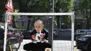 Aktivis mengenakan topeng Presiden Rusia Vladimir Putin menangkap bola selama protes di depan kedutaan Rusia menjelang dimulainya Piala Dunia Sepak Bola 2018 di Berlin, Jerman (12/6). (AFP Photo/Tobias Schwarz)