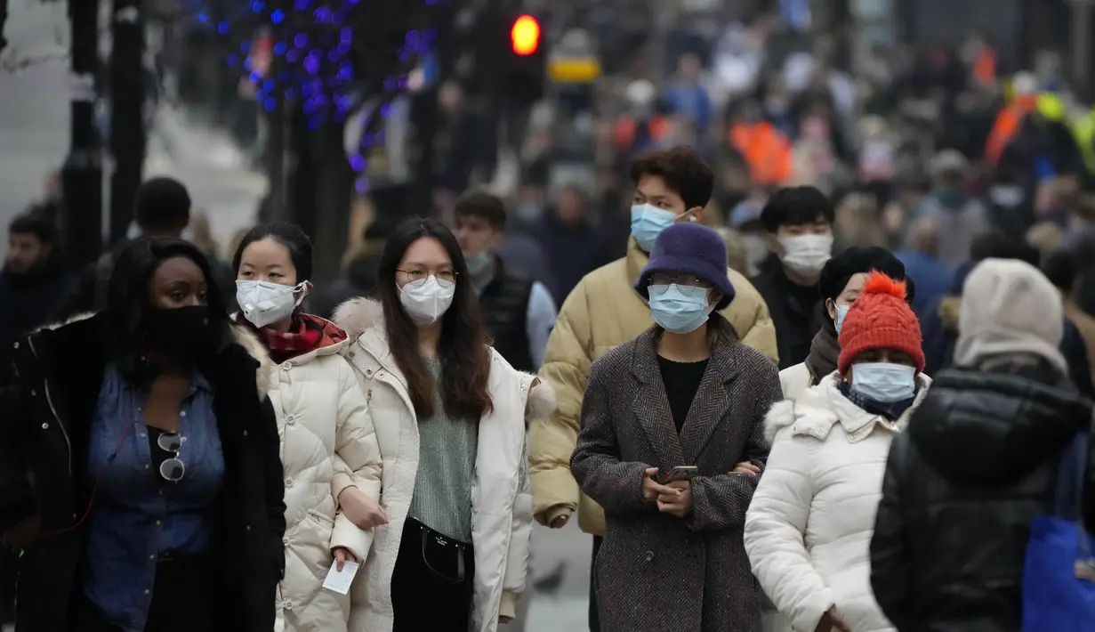 Pembeli yang mengenakan masker memadati Oxford Street, jalan perbelanjaan tersibuk di Eropa, di London, Kamis (23/12/2021). Meskipun pandemi covid-19, salah satu pusat perbelanjaan di London tersebut begitu ramai menjelang Natal. (AP Photo/Frank Augstein)
