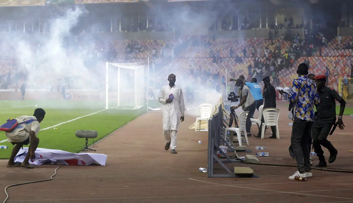 Polisi menembakkan gas air mata untuk mengejar penyerbu lapangan pada akhir pertandingan kualifikasi Piala Dunia 2022 antara Ghana Vs Nigeria di Stadion Moshood Abiola, Abuja, Nigeria, 29 Maret 2022. Fans Nigeria ngamuk setelah gagal lolos ke Piala Dunia 2022. (AP Photo/Sunday Alamba)
