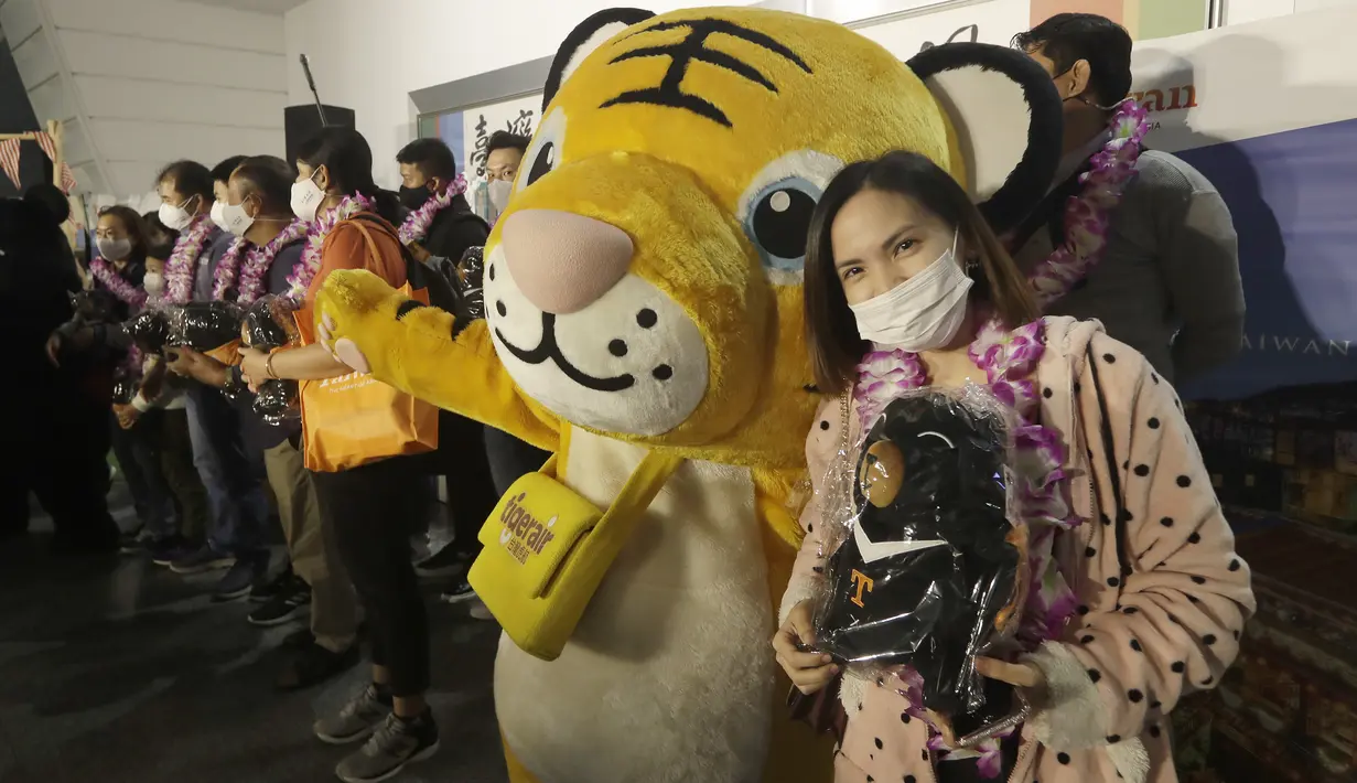 Rombongan pertama wisatawan asing berfoto setelah tiba di Bandara Internasional Taoyuan di Taoyuan, Taiwan Utara, Kamis (13/10/2022). Taiwan telah melaporkan 6,3 juta kasus domestik sejak awal tahun, didorong oleh varian Omicron yang lebih menular. (AP Photo/Chiang Ying-ying)