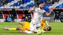Striker Real Madrid, Karim Benzema, terjatuh saat berebut bola dengan kiper Sevilla, Bruno, pada laga Liga Spanyol di Stadion Alfredo di Stefano, Minggu (10/5/2021). Kedua tim bermain imbang 2-2. (AP/Manu Fernandez)