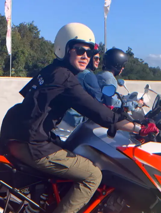 Dian Ayu Lestari jadi lady biker di IKN mengendarai motor KTM orange putih. Ia mengenakan kemeja PDL lengan panjang dengan celana cargo hijau olive. [@raffinagita1717]