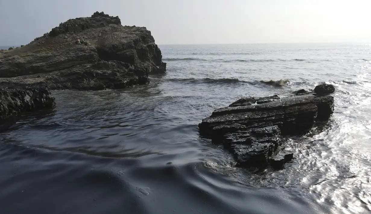 Tumpahan minyak menutupi pantai di pantai Cavero di Ventanilla, Callao, Peru, Senin (17/1/2022). Otoritas setempat dan pekerja kilang La Pampilla membersihkan tumpahan minyak yang terjadi akibat gelombang tsunami yang dipicu letusan gunung api bawah laut di Tonga.  (AP Photo/Martin Mejia)