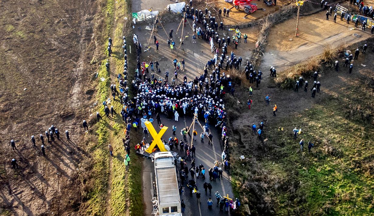 Polisi dan demonstran bertemu di sebuah jalan di Desa Luetzerath dekat Erkelenz, Jerman, 10 Januari 2023. Desa Luetzerath diduduki oleh aktivis iklim yang berjuang melawan penghancuran desa untuk memperluas tambang batu bara Garzweiler dekat perbatasan Belanda. (AP Photo/Michael Probst)
