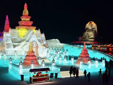 Sejumlah orang mengunjungi Harbin Ice-Snow World di Harbin di provinsi Heilongjiang, Tiongkok (2/1). Bangunan atau istana yang terbuat dari balok es ini dipenuhi cahaya yang berwarna-warni. (AFP Photo/China Out)