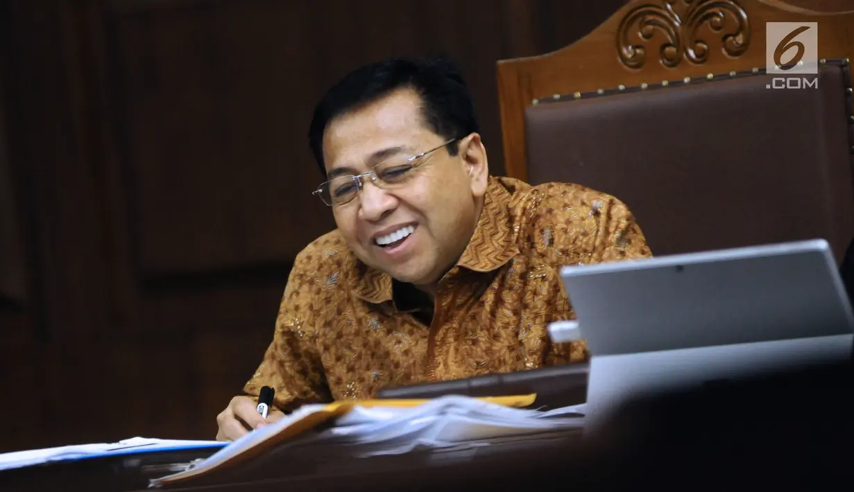 Terdakwa dugaan korupsi proyek e-KTP, Setya Novanto tersenyum saat menyimak keterangan saksi Charles Sutanto Ekapradja pada sidang lanjutan di Pengadilan Tipikor, Jakarta, Senin (22/1). Sidang menghadirkan sejumlah saksi. (Liputan6.com/Helmi Fithriansyah)