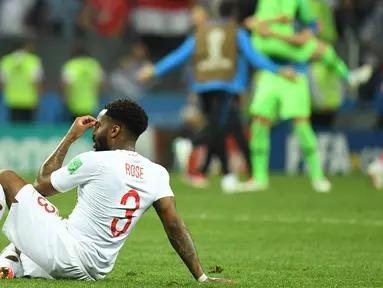 Bek timnas Inggris, Danny Rose terlihat kecewa sambil duduk di lapangan seusai babak semifinal Piala Dunia 2018 melawan Kroasia di Stadion Luzhniki, Rabu (11/7). Rose menyita perhatian lantaran mengenakan kaus kaki yang berlubang. (AFP/Kirill KUDRYAVTSEV)