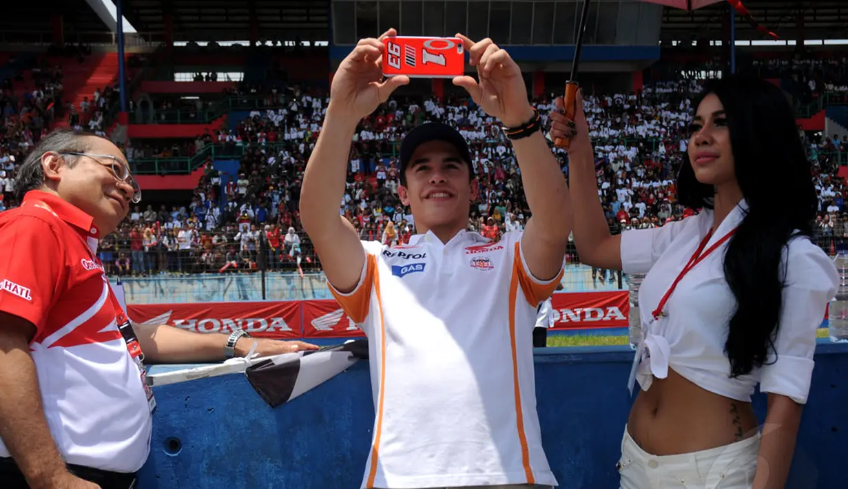 Juara Dunia MotoGP 2013 dan 2014, Marc Marquez (tengah) memotret para penggemarnya saat berlangsungnya acara Meet & Greet di Sirkuit Sentul, Bogor, (21/10/2014). (Liputan6.com/Helmi Fithriansyah)