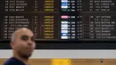 Penumpang berjalan melewati layar informasi keberangakatan di Bandara Brussels, Zaventem, Belgia, Rabu (13/2). Penerbangan pemerintah dan militer tidak terpengaruh dengan adanya mogok nasional. (AP Photo/Geert Vanden Wijngaert)