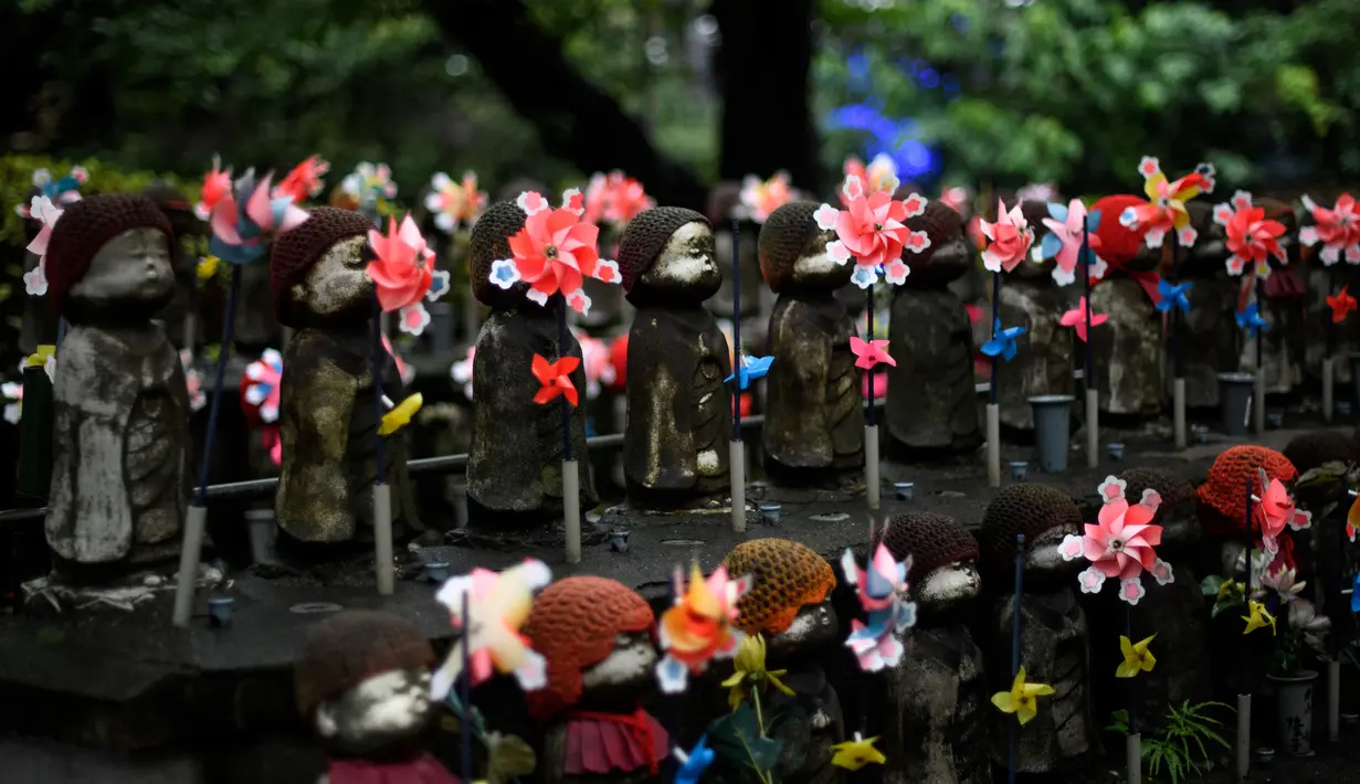 Patung-patung Jizo terlihat di Kuil Zojoji, Tokyo pada 22 Juni 2020. Jizo adalah pelindung dari anak-anak yang belum sempat lahir atau meninggal dalam kandungan dan saat masih bayi. (Photo by Philip FONG / AFP)