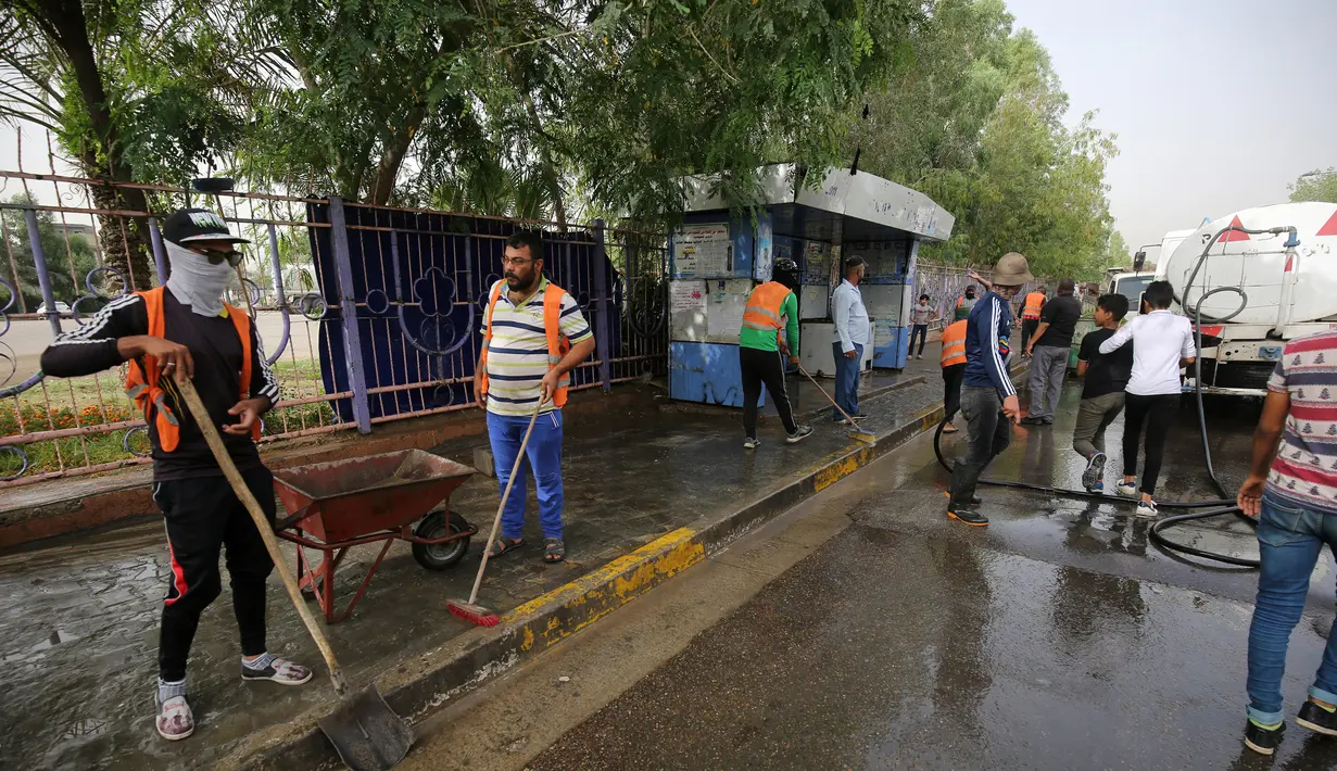 Pekerja kota Irak membersihkan tempat serangan bom bunuh diri semalam di pinggiran Syiah Baghdad di al-Shoala (24/5). Empat orang tewas dan beberapa lainnya terluka ketika seorang pembom bunuh diri menyerang kafe di Baghdad. (AFP Photo/Ahmad Al-Rubaye)