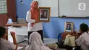 Salah satu guru memberikan penjelasan kepada murid SDN Pondok Labu 14 terkait pergantian Presiden dan Wakil Presiden. (Liputan6.com/Herman Zakharia)
