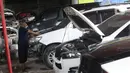 Mekanik mengecek mesin mobil yang terendam banjir di sebuah bengkel di Jakarta, Rabu (8/1/2020). Kerusakan pada mobil yang terendam banjir meliputi interior, kabel dan kelistrikan, serta bagian mesin. (Liputan6.com/Angga Yuniar)