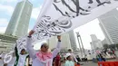 Massa yang dominan mengenakan warna putih melakukan aksi di Bundaran HI, Jakarta, Minggu (16/8/2015). Parade Tauhid yang diikuti berbagai organisasi massa Islam ini digelar dalam rangka mensyukuri kemerdekaan RI ke 70 tahun. (Liputan6.com/Faizal Fanani)
