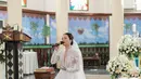 Rambutnya ditata sleek look; dibelah tengah dan diberi veil putih yang serasi dengan gaun pengantinnya. [Foto: Instagram/anggimarito]
