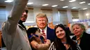 Pengunjung berswafoto dengan patung Presiden AS Donald Trump yang terbuat dari cokelat dalam Festival Cokelat Turki di museum militer Istanbul, 25 Maret 2017. Butuh dua hari untuk menyelesaikan patung setengah badan Trump. (AP Photo/Lefteris Pitarakis)