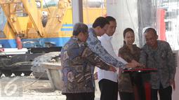 Presiden Jokowi (tengah) dan Menteri BUMN Rini Soemarno (kedua kanan) menekan tombol sebagai tanda dimulainya Groundbreaking Light Rail Transit (LRT) Indonesia di Jakarta, Rabu (9/9). (Liputan6.com/Faizal Fanani)