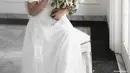 Dalam potret ini, Donna Agnesia terlihat anggun dalam balutan gaun putih dengan aksen renda. Gaun ini merupakan rancangan desainer Arturro. (Instagram/riomotret)