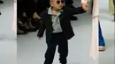 Rayyanza melenggang di catwalk bersama sang mama, Nagita, mengenakan koleksi kolaborasi Zaskia Sungkar x NASL. Adik Rafathar itu tampil menggemaskan bergaya formal mengenakan jas berwarna hitam yang dipadukan dengan long pants warna senada, serta striped shirt sebagai inner. Penampilannya dipermanis dengan kacamata hitam dan sneakers warna senada. [Foto: IG/@raffinagita1717].