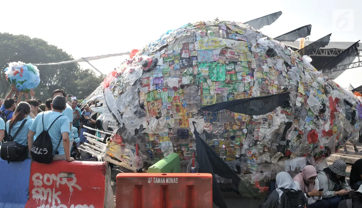 Karya instalasi "monster plastik" dalam pawai bebas plastik di Taman Aspirasi Monas, Jakarta, Minggu (21/7/2019). Monster plastik menyerupai ikan Angler Fish setinggi 4 meter itu sebagai bentuk bahaya atau dampak buruk penggunaan kantong plastik sekali pakai. (merdeka.com/Iqbal S Nugroho)