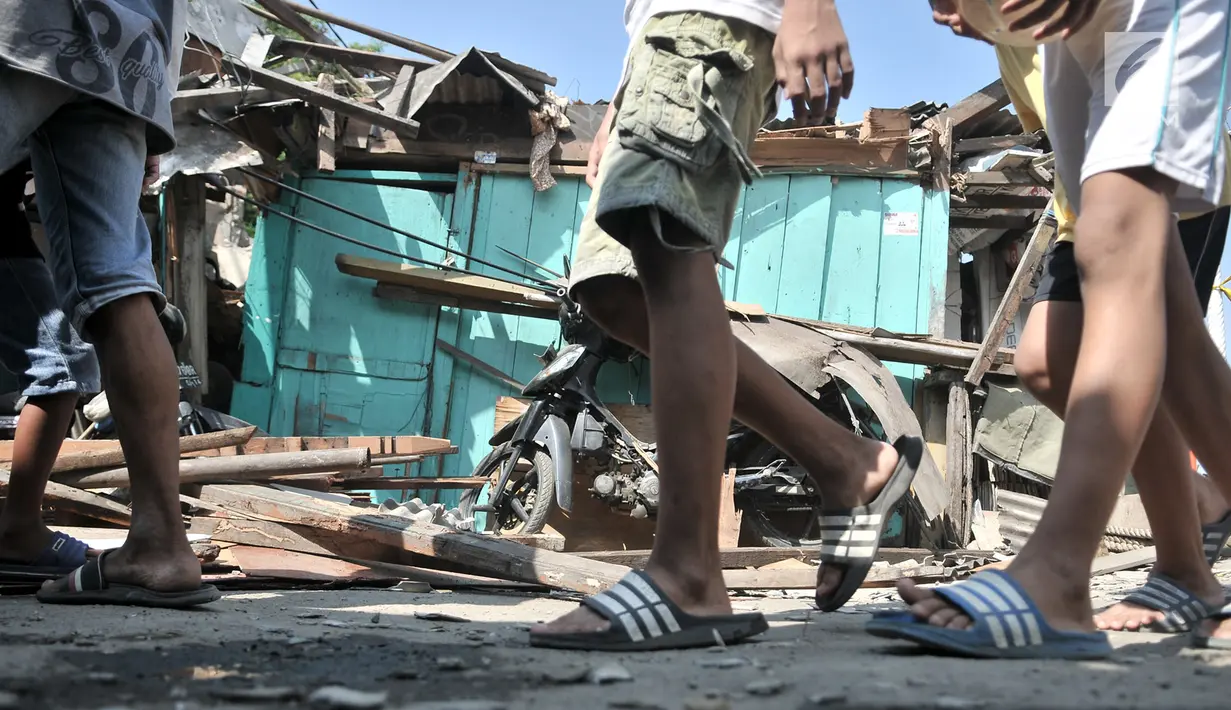 Anak-anak melintasi rumah yang ambruk akibat crane jatuh di kawasan Kemayoran, Jakarta, Kamis (6/12).  (Merdeka.com/Iqbal S. Nugroho)