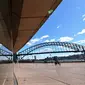 Seorang pria mengendarai sepeda di depan Harbour Bridge, Sydney, Australia, Sabtu (26/6/2021). Pihak berwenang melakukan lockdown beberapa area pusat kota terbesar di Australia untuk menantisipasi penyebaran virus corona COVID-19 varian Delta yang sangat menular. (Saeed KHAN/AFP)