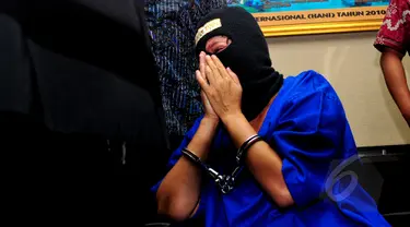 SA (45) tampak menangis di hadapan petugas di Kantor BNN, Jakarta, Selasa (19/5/2015). SA dan AN, yang diduga menjadi kurir, ditangkap aparat BNN dengan barang bukti 12,29 kilogram sabu. (Liputan6.com/Yoppy Renato)