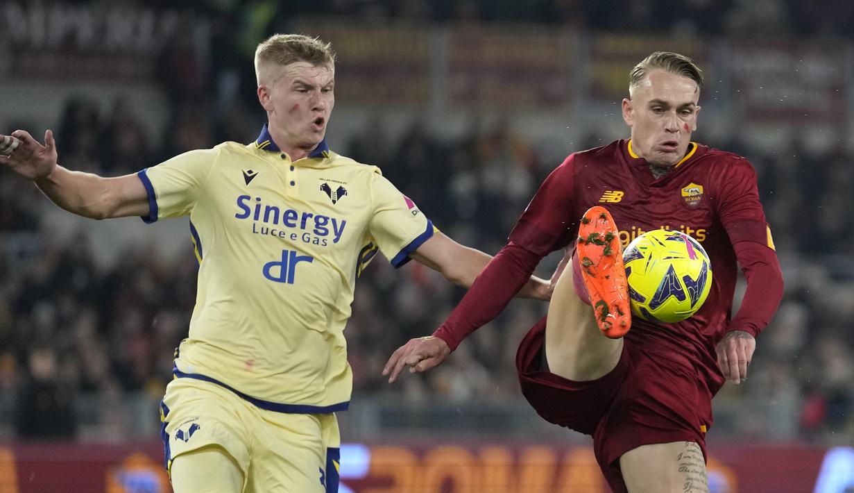 <p>Pemain AS Roma, Rick Karsdorp (kanan) berebut bola dengan pemain Hellas Verona, Josh Doig Verona's Josh Doig dalam laga pekan ke-23 Liga Italia 2022/2023 di Olimpic Stadium, Roma, Italia (19/2/2023). (AP Photo/Andrew Medichini)</p>