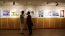 Pengunjung melihat karikatur seniman Iran  yang menampilkan Ratu Elizabeth II Inggris sebagai "bajak laut"  di Teheran (30/7/2019). Hubungan tegang antara Teheran dan London memburuk ketika Angkatan Laut Kerajaan Inggris menyita kapal tanker minyak "Grace 1" Iran pada 4 Juli. (AFP Photo/Atta Kenare)