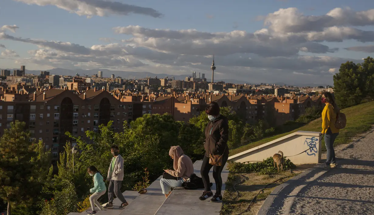 Orang-orang duduk di taman Cerro del Tio Pio di Madrid, Spanyol (14/10/2020). Berbagai wilayah di Spanyol, termasuk Navarra utara dan timur laut Catalonia, sedang merencanakan atau menerapkan pembatasan baru terhadap penyebaran virus corona baru. (AP Photo/Manu Fernandez)