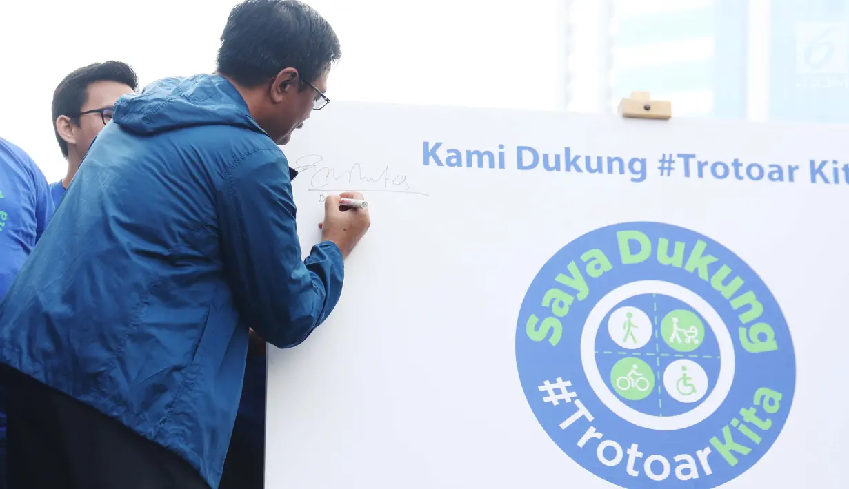 Gubernur DKI Jakarta Djarot Saiful Hidayat menandatangani komitmen pencanangan program #TrotoarKita di area car free day Bundaran HI, Minggu (8/10). Proses pengerjaan program ini akan dilakukan pada Desember 2017 - Juli 2018. (Liputan6.com/Angga Yuniar)