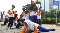 Aksi sejumlah anak-anak dari rumah belajar dan berkarya Rumah Amalia yang melakukan pementasan teater dikawasan Jalan Sudirman pada Hari Bebas Kendaraan Bermotor (HBKB) atau Car Free Day (CFD) di Jakarta, Minggu (5/3). (Liputan6.com/Helmi Afandi)