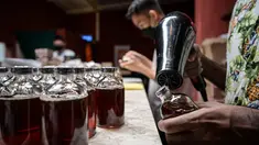 Seorang karyawan menyegel sebotol minuman ExtraGineca, minuman yang terinspirasi oleh vaksin virus corona Covid-19, di sebuah bar koktail di George Town di pulau Penang, Malaysia (8/9/2021). (AFP/Mohd Rasfan)