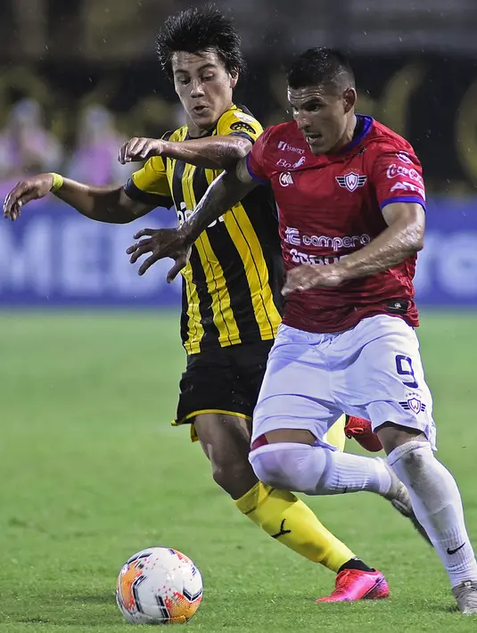 Gelandang Penarol Uruguay, Facundo Pellistri (kiri) berebut bola dengan gelandang Jorge Wilstermann Cristian Chavez pada pertandingan Copa Libertadores di stadion Campeon del Siglo, pada 11 Maret 2020. MU dikabarkan merogoh kocek sekitar 10 juta euro demi Facundo Pellistri. (Dante Fernandez / AFP)