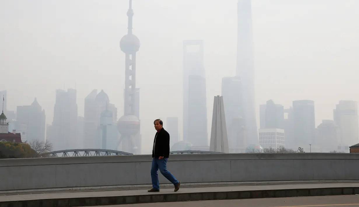 Warga berjalan ditengah kabut asap tebal yang menyelimuti Shanghai, Cina, 2 Januari 2017. Kabut tebal ini membuat sejumlah warga mengunakan masker saat beraktivitas. (REUTERS/Aly Song)